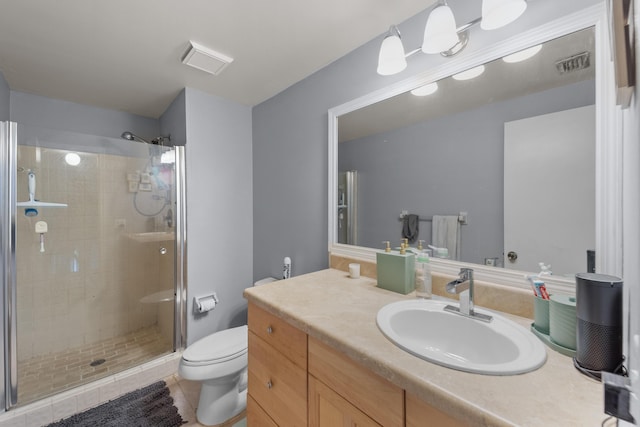 bathroom with tile patterned floors, toilet, a shower with shower door, and vanity