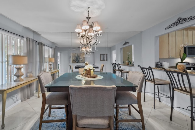 tiled dining space featuring a chandelier