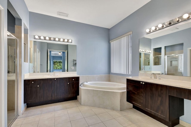 bathroom featuring a stall shower, visible vents, a bath, tile patterned flooring, and a sink