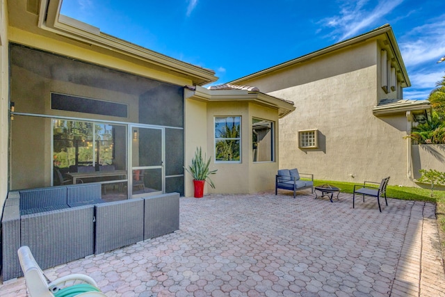 view of patio / terrace with an outdoor living space with a fire pit and a sunroom