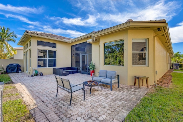 rear view of house with a patio, central AC, an outdoor living space with a fire pit, and stucco siding