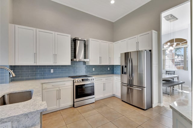 kitchen featuring white cabinets, wall chimney exhaust hood, stainless steel appliances, and a sink