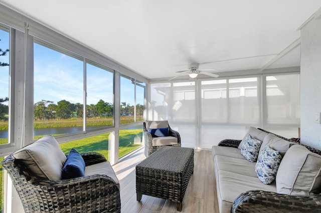 sunroom with a water view and ceiling fan