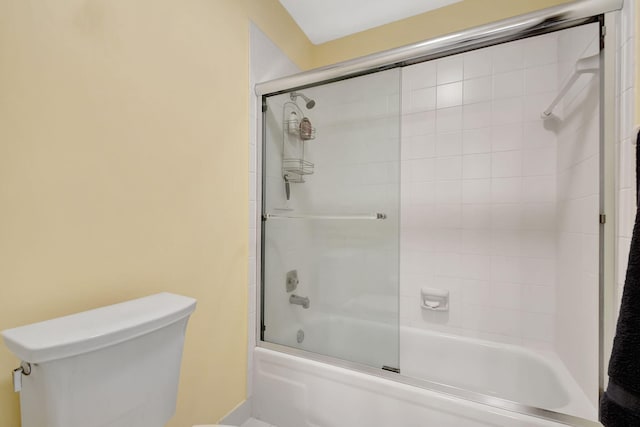 bathroom featuring enclosed tub / shower combo and toilet