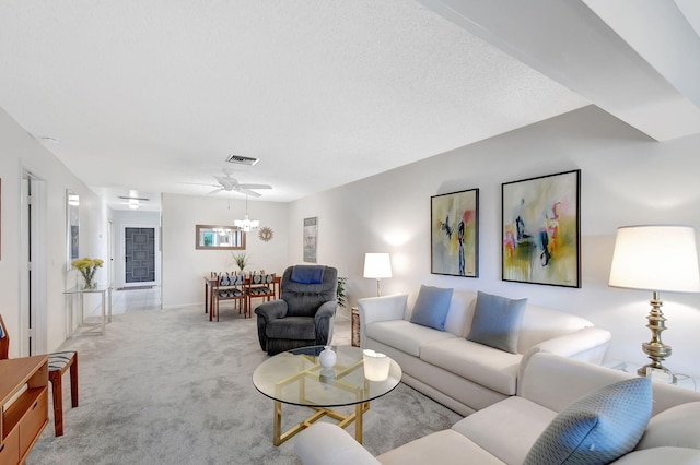 carpeted living room featuring a chandelier