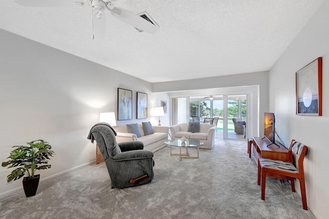 carpeted living room with a textured ceiling and ceiling fan