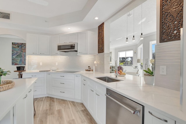 kitchen featuring sink, white cabinets, light stone counters, light hardwood / wood-style floors, and stainless steel appliances