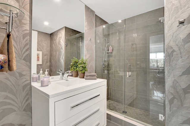 bathroom featuring vanity, tile walls, and a shower with shower door