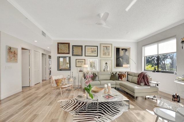 living room featuring crown molding, ceiling fan, light hardwood / wood-style floors, and a textured ceiling