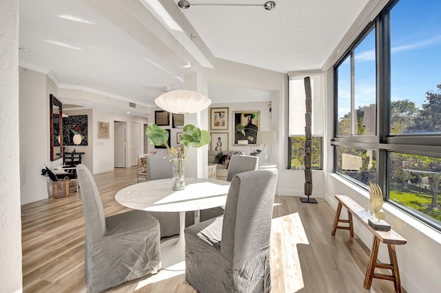 dining area with ornamental molding and light wood-type flooring