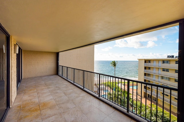 balcony with a water view and a beach view