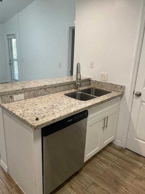 kitchen with white cabinetry, dishwasher, sink, and light stone counters