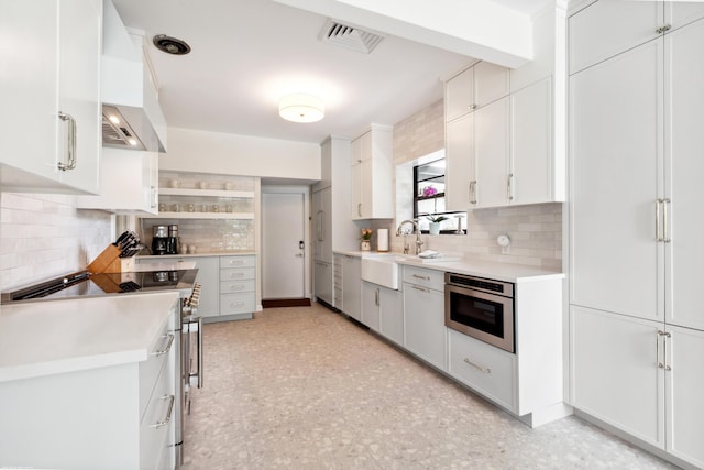 kitchen featuring white cabinetry, sink, oven, custom exhaust hood, and high end stainless steel range