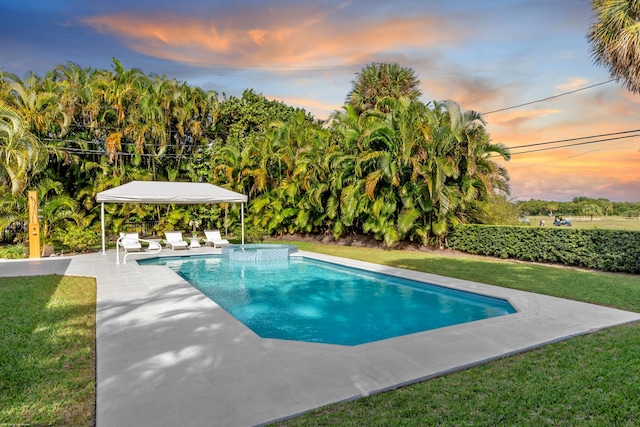 pool at dusk featuring a gazebo, a yard, and a patio