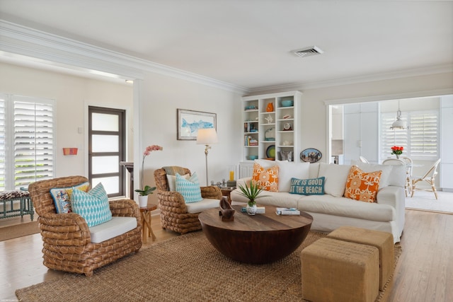 living room featuring crown molding and light hardwood / wood-style flooring