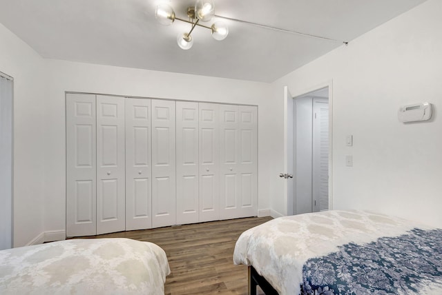 bedroom with dark hardwood / wood-style flooring and a closet