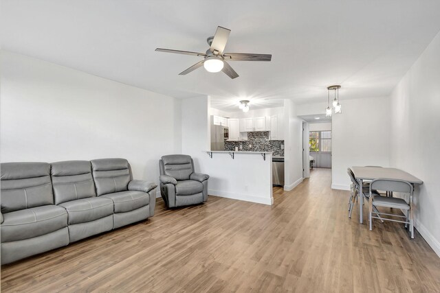 living room with ceiling fan and light wood-type flooring