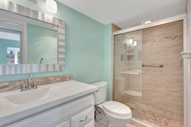 bathroom with vanity, a shower stall, and toilet