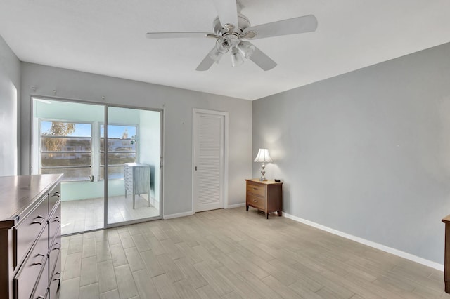 spare room with light wood-type flooring, ceiling fan, and baseboards