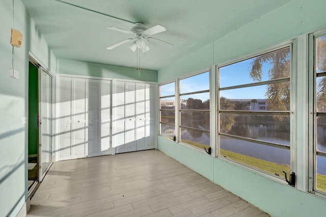 unfurnished sunroom featuring ceiling fan