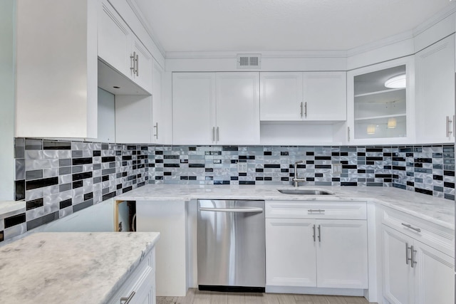 kitchen with visible vents, backsplash, stainless steel dishwasher, white cabinetry, and a sink