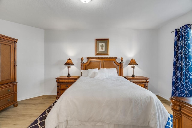 bedroom with light wood-type flooring and baseboards