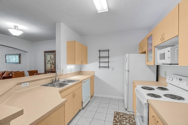 kitchen featuring sink, light brown cabinets, a textured ceiling, and white appliances