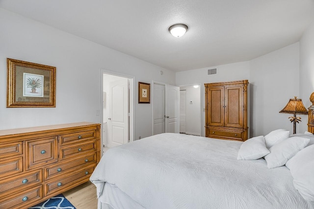 bedroom featuring light wood-style floors and visible vents