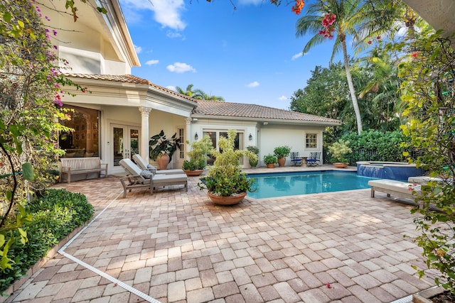 view of swimming pool with a patio area, french doors, and an in ground hot tub