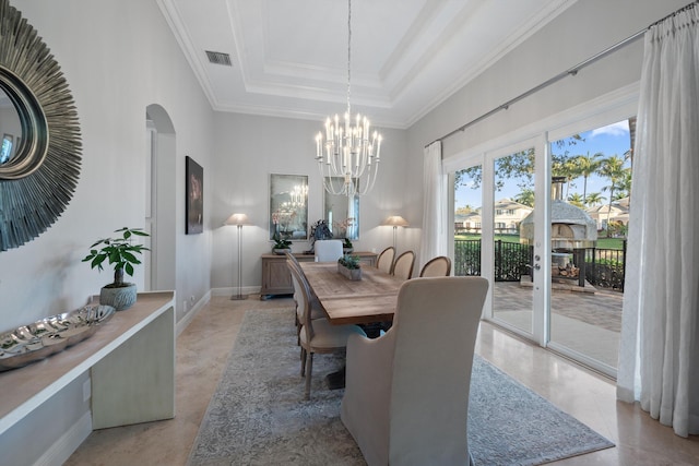 dining area with crown molding, a raised ceiling, a chandelier, and a high ceiling