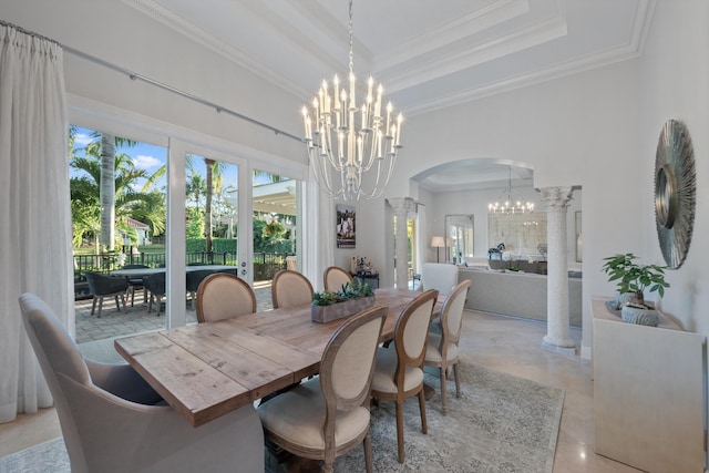 dining space with decorative columns, a high ceiling, ornamental molding, a notable chandelier, and a raised ceiling