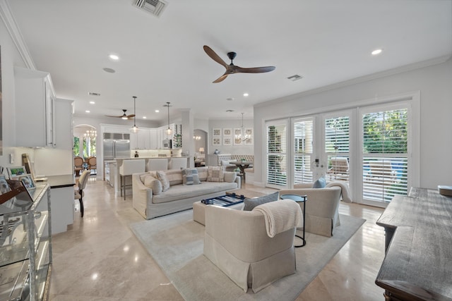 living room featuring crown molding and ceiling fan with notable chandelier