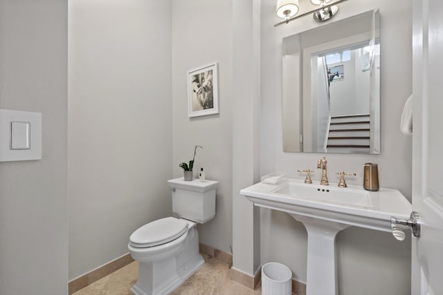 bathroom with sink, toilet, and tile patterned flooring