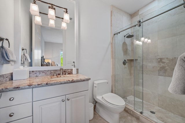 bathroom featuring vanity, toilet, and a shower with shower door