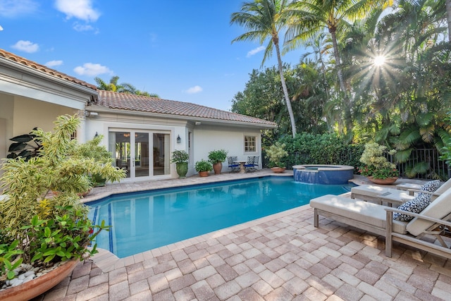 view of pool featuring french doors, an in ground hot tub, and a patio