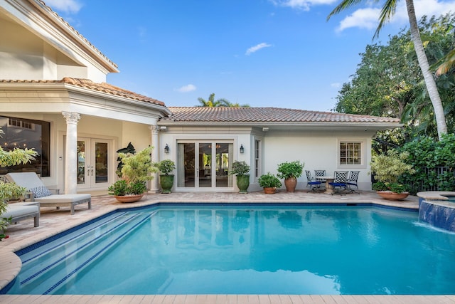 rear view of house featuring a patio, pool water feature, and french doors