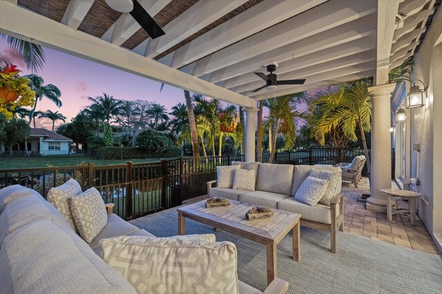 patio terrace at dusk featuring ceiling fan and an outdoor hangout area