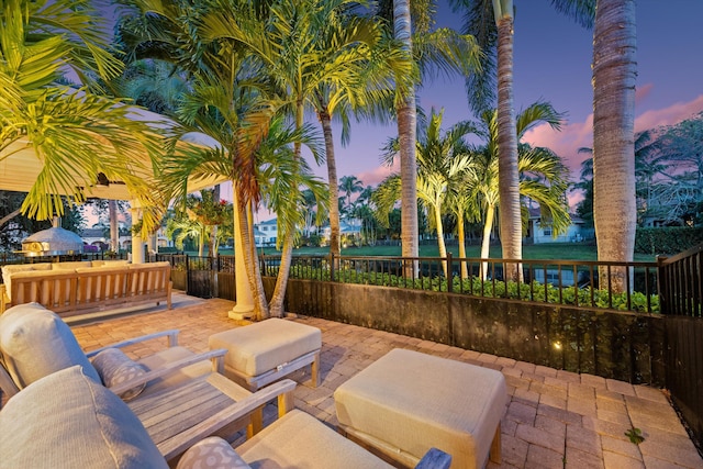 patio terrace at dusk featuring an outdoor living space