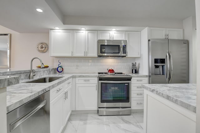 kitchen with white cabinetry, appliances with stainless steel finishes, sink, and decorative backsplash