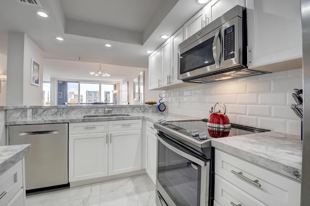 kitchen featuring backsplash, appliances with stainless steel finishes, sink, and white cabinets