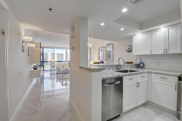 kitchen with sink, dishwasher, white cabinetry, light stone countertops, and kitchen peninsula