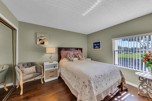 bedroom featuring dark hardwood / wood-style floors, a textured ceiling, and a closet