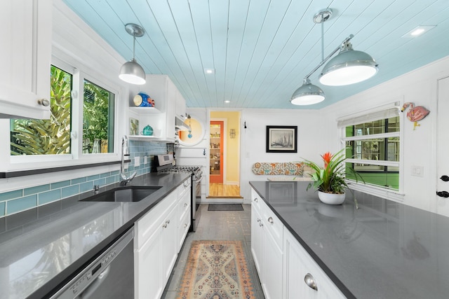 kitchen featuring stainless steel appliances, sink, pendant lighting, and white cabinets