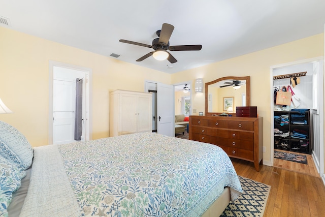 bedroom featuring a closet, a spacious closet, ceiling fan, and light hardwood / wood-style flooring