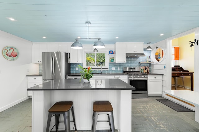 kitchen featuring white cabinetry, sink, stainless steel appliances, and a kitchen bar