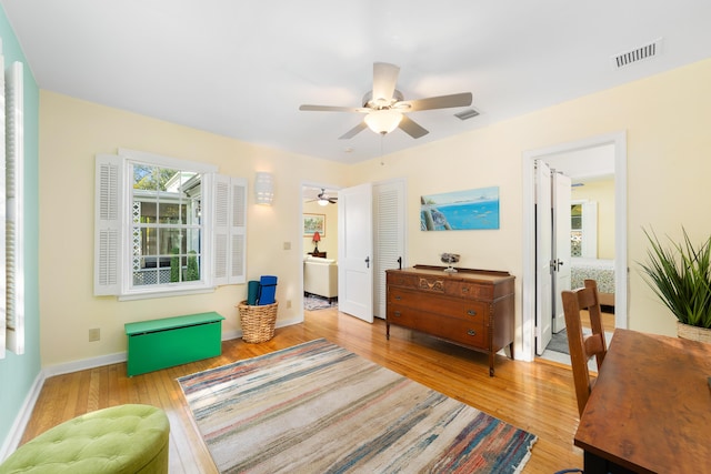 living area featuring light hardwood / wood-style floors and ceiling fan