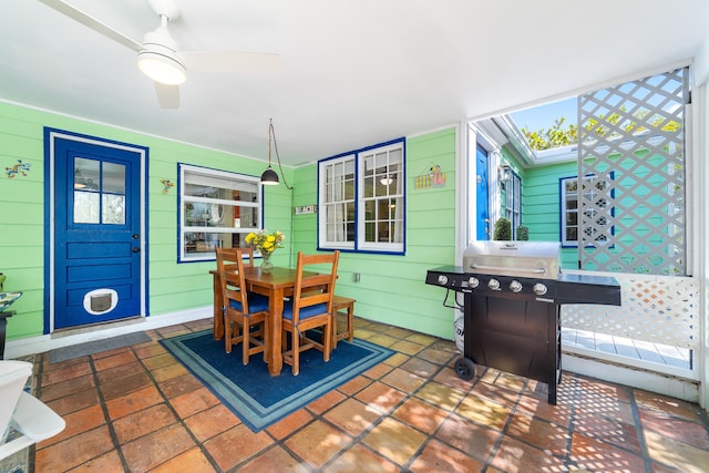 dining space featuring ceiling fan and wooden walls