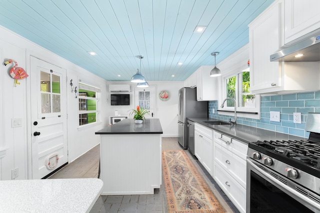 kitchen featuring white cabinetry, hanging light fixtures, stainless steel appliances, ventilation hood, and a kitchen island