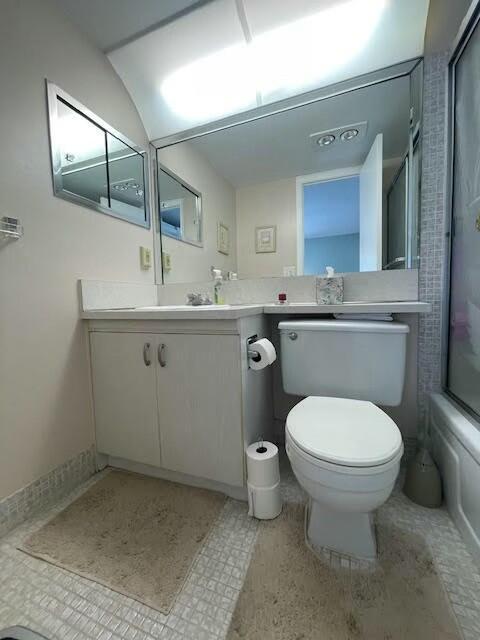 full bathroom featuring vanity, toilet, and combined bath / shower with glass door