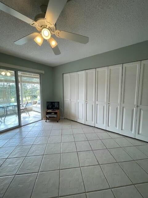 unfurnished living room with light tile patterned floors, a textured ceiling, and ceiling fan